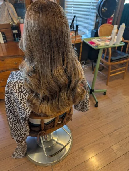 Long, light brown hair blending into golden ends, styled in soft waves