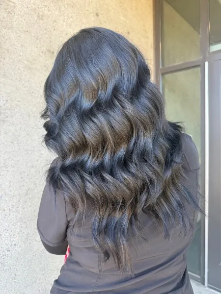 Long, deep brunette hair with soft dimension, styled in glossy waves
