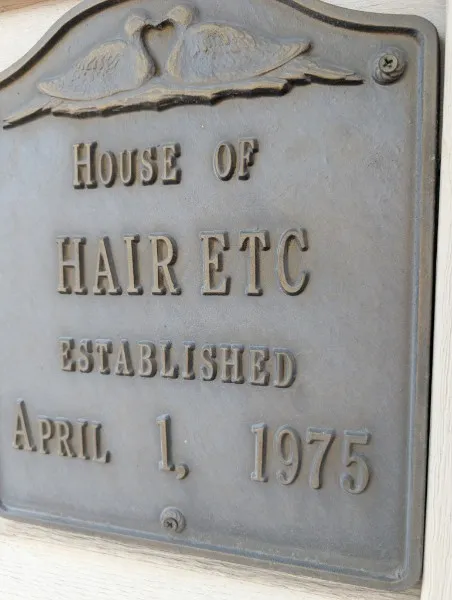 Bronze plaque reading "House of Hair Etc, established April 1, 1975"