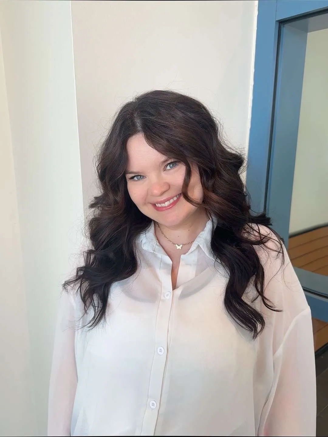 Shenna smiling, with long, dark brunette waves