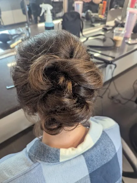 Loose, twisted brunette updo pinned at the nape of the neck