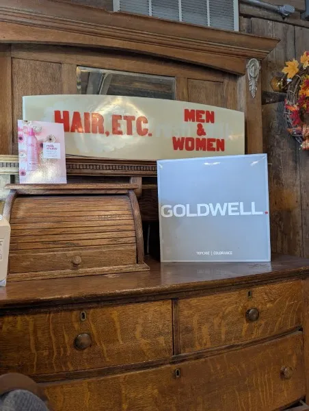 Vintage "Hair, Etc. Men & Women" sign on an antique oak dresser